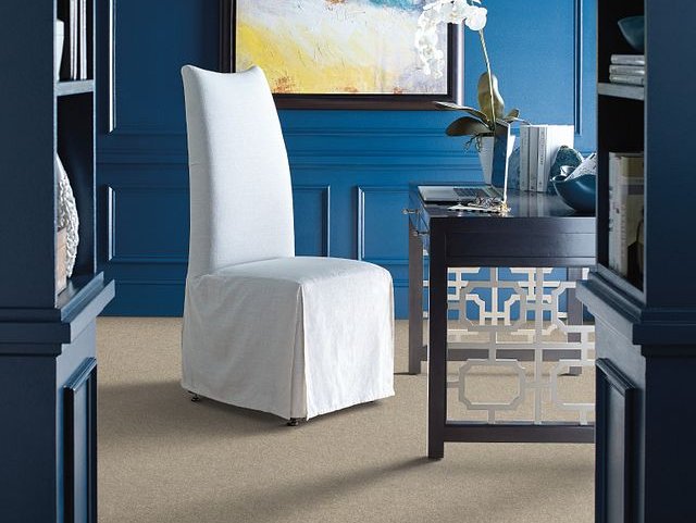 white chair in a room with blue walls and brown carpet